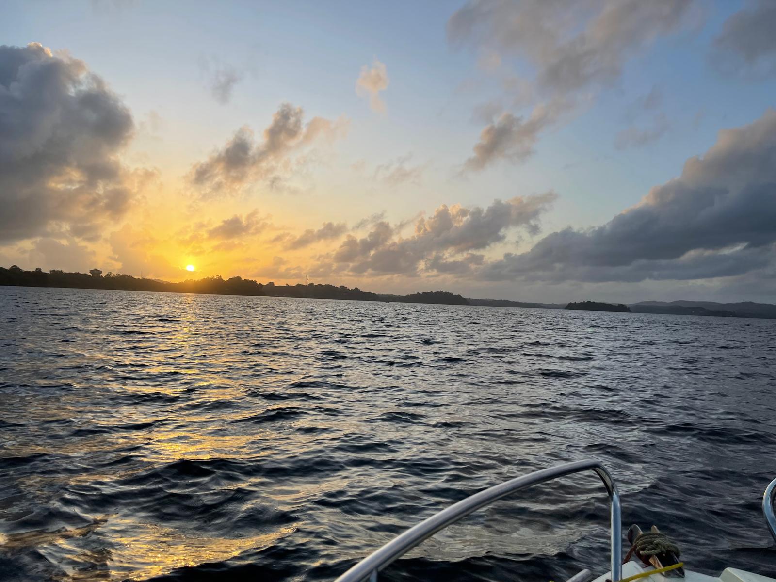 Traditional wooden outrigger canoe navigating Koggala Lake at dusk