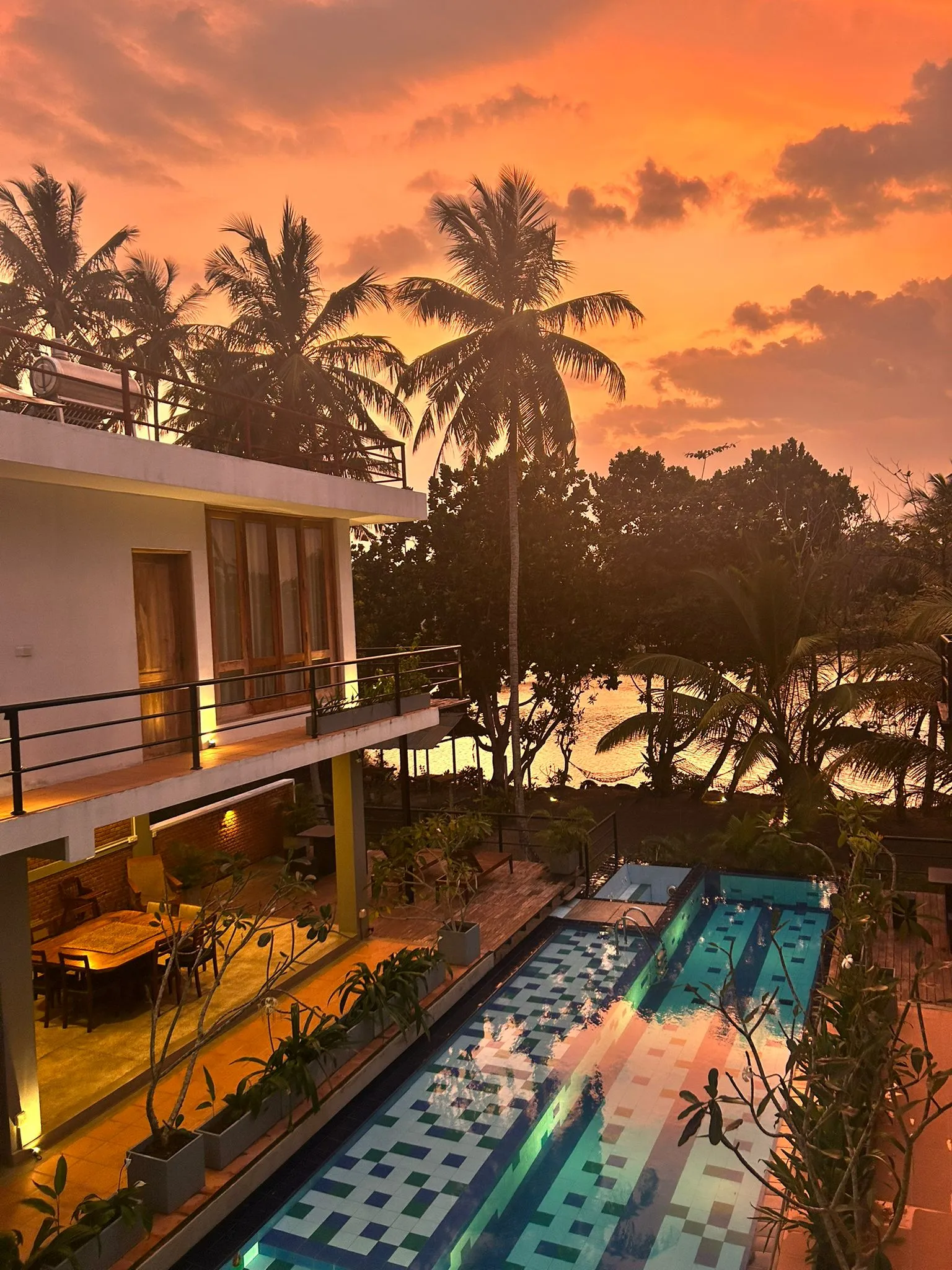 Sunset over Ko Lake Villa's infinity pool and Koggala Lake, Sri Lanka
